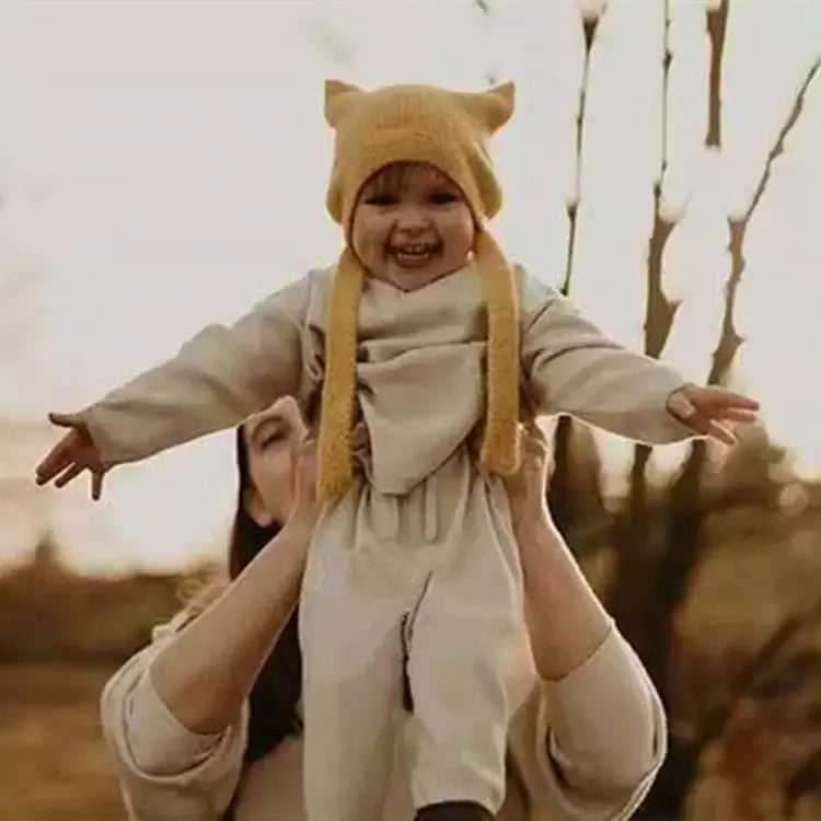 Baby Beanie mit Hasenohren - Kleines Kind trägt eine gelbe Mütze mit Hasenohren, in herbstlicher Umgebung.