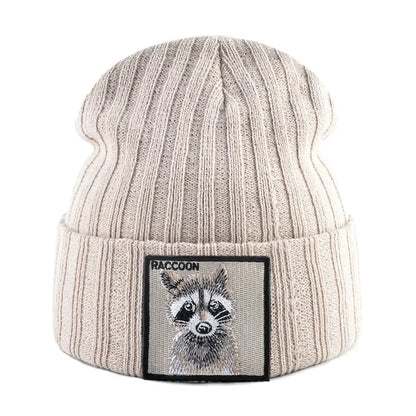 Orange ribbed knit beanie with raccoon patch, measuring 23cm height and 22cm width, featuring a raccoon illustration patch, for cold days.