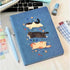 Katzen-Notizbuch A5 Hardcover mit niedlichem Katzen-Design auf blauer Oberfläche, ideal für Notizen und kreative Arbeiten.