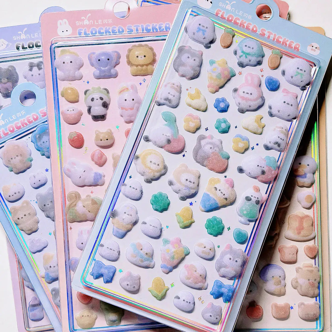Set of pastel-colored 3D animal stickers with glitter, including bear, bunny, and other cute creatures on holographic packaging.