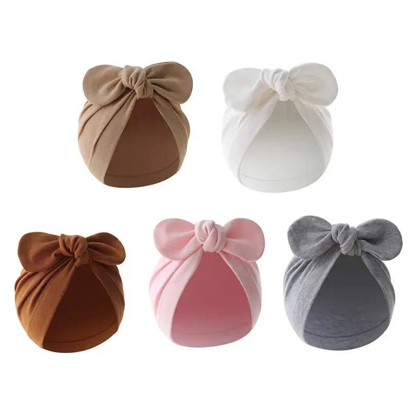 Baby turban hat with bow in white cotton, lightweight and cozy for babies, perfect for casual outings and gifts.
