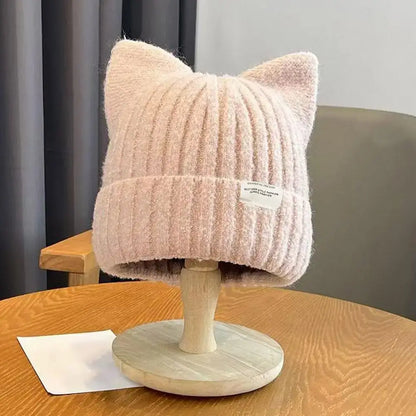 Katzenohren Beanie in rosa, warme Damen Strickmütze mit Katzenohren für Herbst und Winter auf einem Holzständer.
