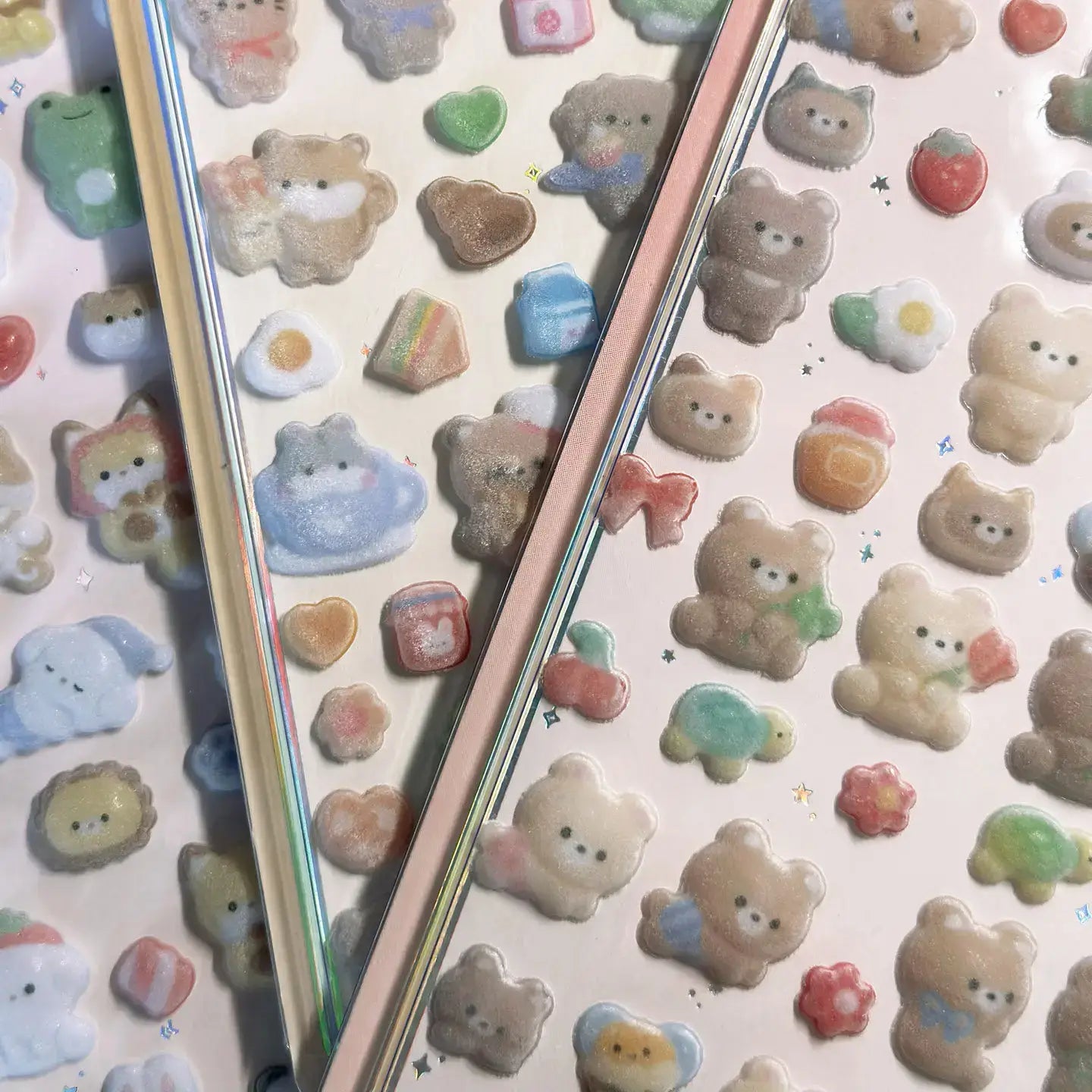 Assorted pastel 3D animal stickers with glitter, featuring bears, rabbits, and hearts, on holographic sticker sheets.