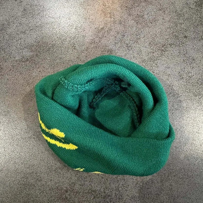 Green knitted beanie with dragon design, folded for warmth, made of soft material, ideal for cold weather and winter wear.