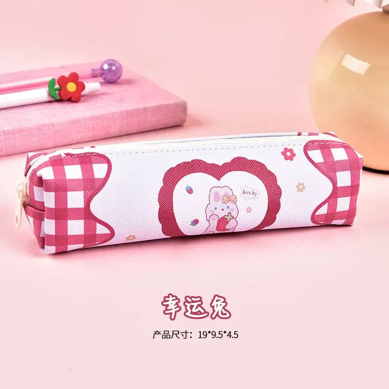 Pink gingham pencil case with adorable cartoon bear and heart speech bubble design, suitable for children’s school supplies.
