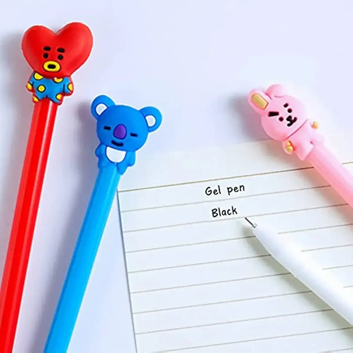 Pink sheet of paper with handwritten notes and colorful gel pens featuring animal-shaped toppers for creative writing